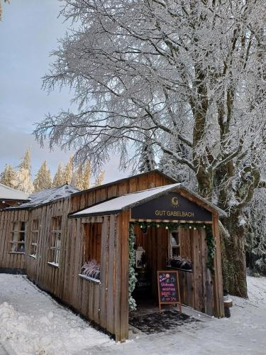 a wooden building with a sign in the snow at BERG & SPA HOTEL GABELBACH in Ilmenau