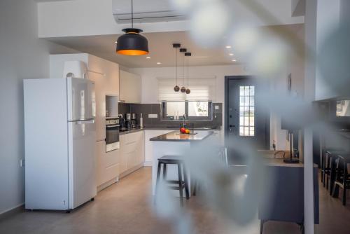 a kitchen with white appliances and a white refrigerator at Oceanfront Oasis with Private Pool Stunning Views in Kérynia