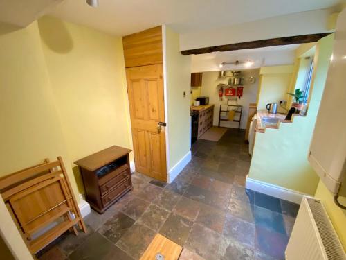 a kitchen with a hallway with a sink and a counter at Bumblebee Cottage in Knowle
