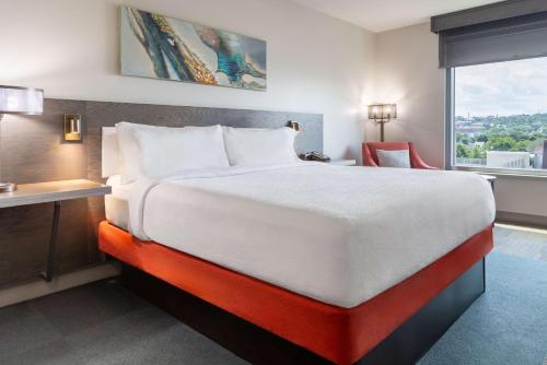 a hotel room with a large bed and a window at Hilton Garden Inn Fredericton in Fredericton