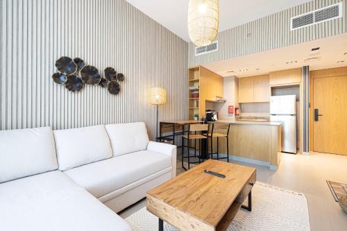 a living room with a white couch and a table at Wonderful Whole Apartment in Sharjah - Aura in Sharjah