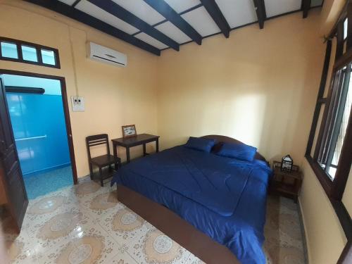 a bedroom with a bed and a table and a window at Sabai ça Baille Guesthouse in Pakse