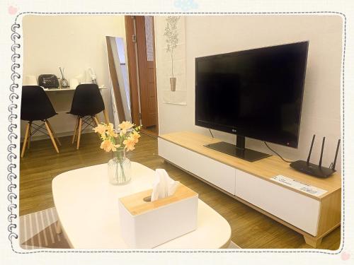 a living room with a flat screen tv on a white cabinet at Yong Yong House in Seoul