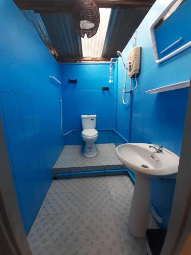 a blue bathroom with a toilet and a sink at Sabai ça Baille Guesthouse in Pakse