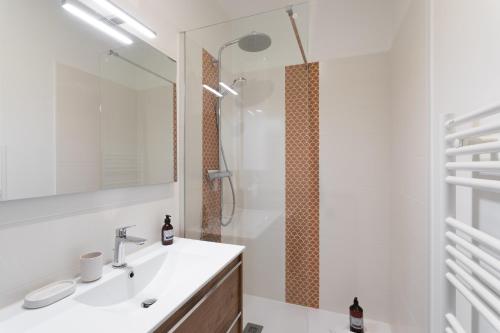 une salle de bain avec un lavabo et une douche dans l'établissement Coquillages et Crustacés - Apt avec balcon vue mer, à Saint-Malo