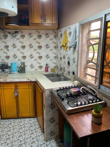 a kitchen with a stove and a sink at The Nest in Yaoundé