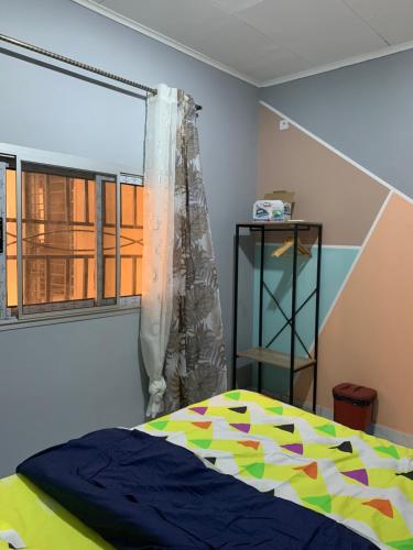 a bedroom with a bed and a window at The Nest in Yaoundé