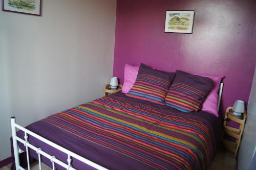 a bedroom with a bed with a purple wall at Le Sel J'm in Salins-les-Bains