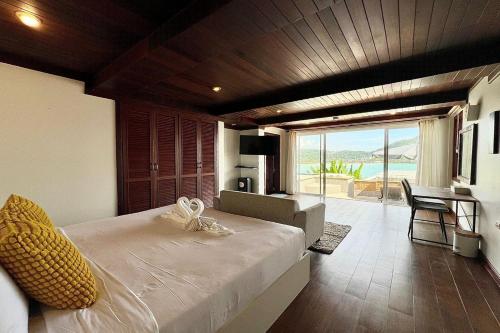 a bedroom with a bed with a view of the ocean at Panorama Ocean Villas, Kamala in Surin Beach