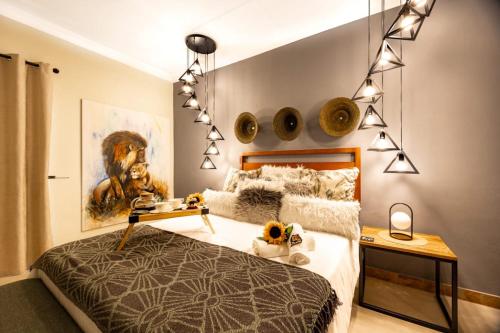 a bedroom with a bed and a painting on the wall at Zabini Lodge and Game Drives in Nelspruit