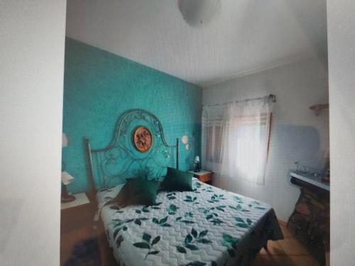 a bedroom with a bed with a green wall at two-room apartment with parking space in Rio nellʼElba
