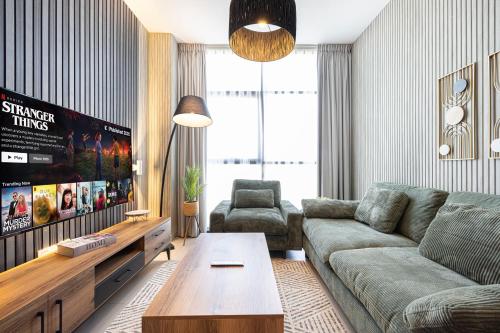 a living room with a couch and a tv at شقة رائعة بغرفة نوم واحدة وصالة في الممشى - The Sapphire in Sharjah