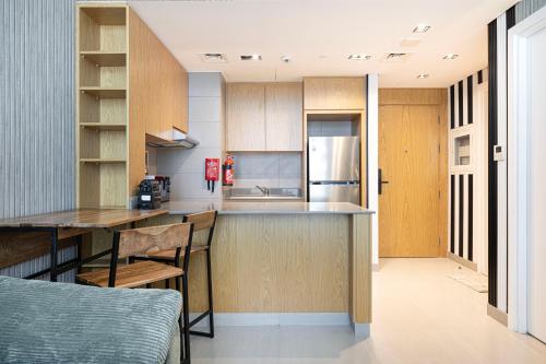 a kitchen with a table and a counter top at شقة رائعة بغرفة نوم واحدة وصالة في الممشى - The Sapphire in Sharjah