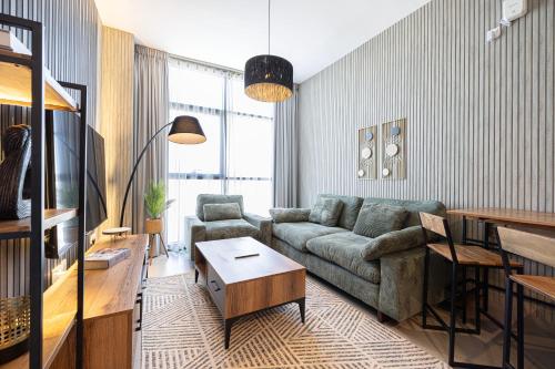 a living room with a couch and a table at شقة رائعة بغرفة نوم واحدة وصالة في الممشى - The Sapphire in Sharjah