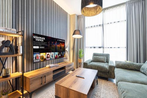 a living room with a couch and a tv at شقة رائعة بغرفة نوم واحدة وصالة في الممشى - The Sapphire in Sharjah