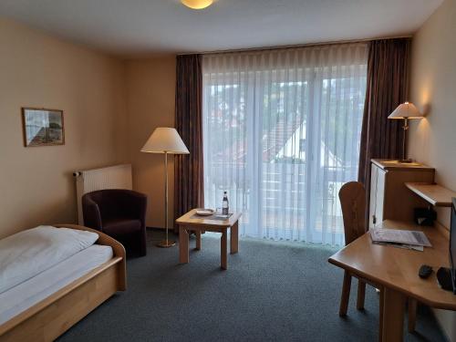 a hotel room with a bed and a large window at Hotel Heikenberg in Bad Lauterberg