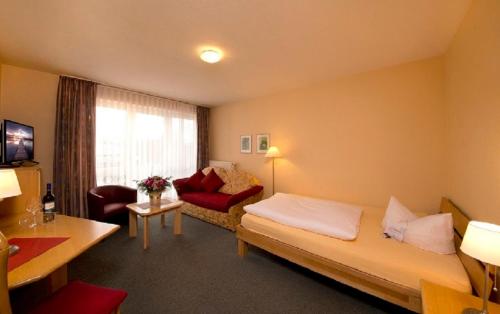 a hotel room with a bed and a couch at Hotel Heikenberg in Bad Lauterberg