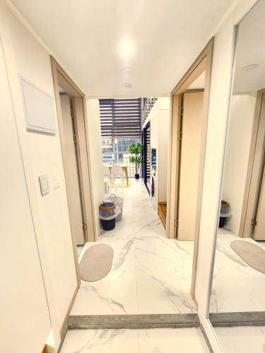 a hallway in a building with white walls and marble floors at Majestic Seoul Stay Central in Seoul