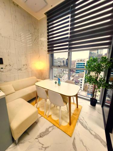 a living room with a table and a couch at Majestic Seoul Stay Central in Seoul