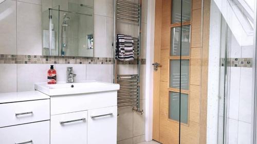 a bathroom with a sink and a glass door at Warrenpoint Countryside House-3bedroom- Private Garden in Newry