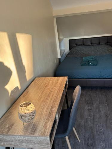 Cette chambre dispose d'une table en bois et d'un lit. dans l'établissement Maison de ville parking privé, à Bourges