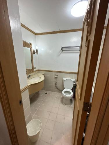 a small bathroom with a toilet and a sink at Canyon Cove by Lawton in Nasugbu