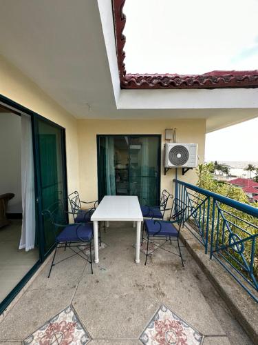 a patio with a white table and chairs on a balcony at Canyon Cove by Lawton in Nasugbu