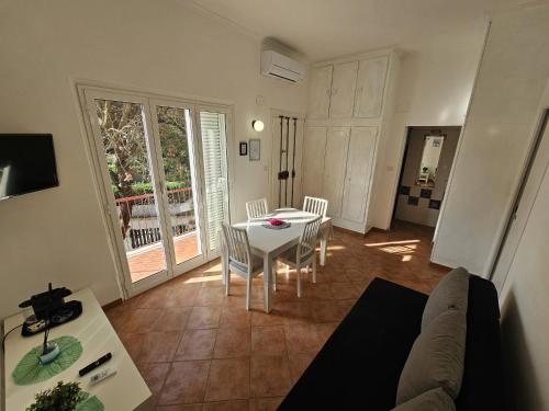 a living room with a couch and a table and chairs at Stella Marina Apartment in Fregene