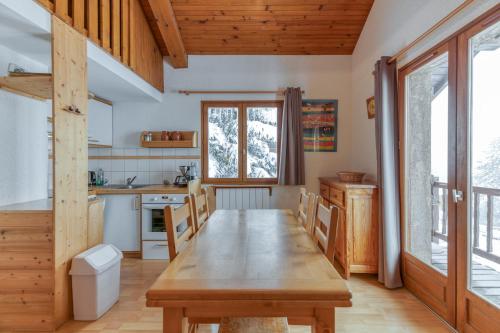 une salle à manger avec une table en bois dans une cuisine dans l'établissement Souveraine 3 Charmant Appartement, à Villard-Reculas