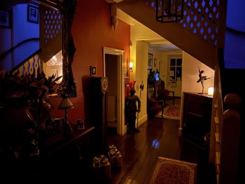 a person standing in a hallway of a house at Plas Tan-Yr-Allt Historic Country House B&B in Porthmadog