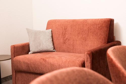 a orange chair with a gray pillow on it at Gasthaus Jakober in Alpbach