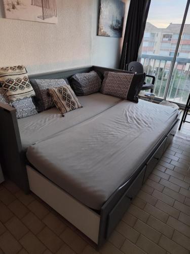 un grand lit dans une chambre avec une fenêtre dans l'établissement Chez Fleur, au Grau-du-Roi