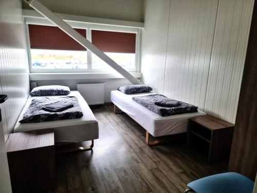 a room with two beds and a window at Vlantana poilsio namai in Dauparai