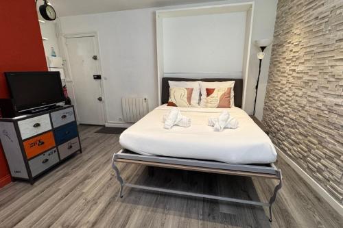 une chambre avec un lit et une télévision dans l'établissement Studio Bercy - Terrasse - Paris, à Paris