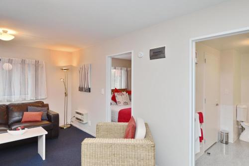 a living room with a couch and a bedroom at Addington Court Motel in Christchurch