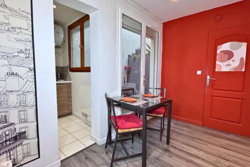 une salle à manger avec une table et une porte rouge dans l'établissement Studio Bercy - Terrasse - Paris, à Paris