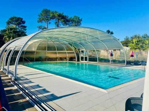 einen Pool in einem Glashaus mit Pool in der Unterkunft Le Nid des Viviers - Bungalow au bord de l'eau in Lège-Cap-Ferret