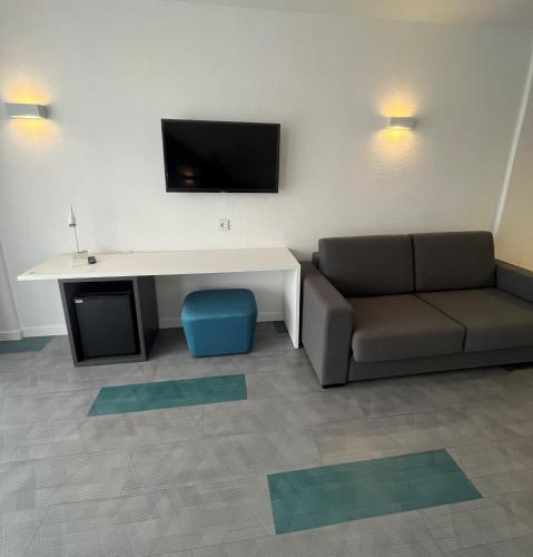 a living room with a couch and a table and a tv at Complejo BLUESEA Puerto Resort compuesto por Hotel Canarife y Bonanza Palace in Puerto de la Cruz