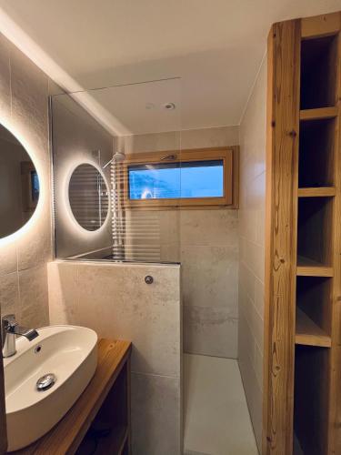 une salle de bain avec un lavabo et un miroir dans l'établissement Appartement de Montagne au Centre de la Clusaz, à La Clusaz