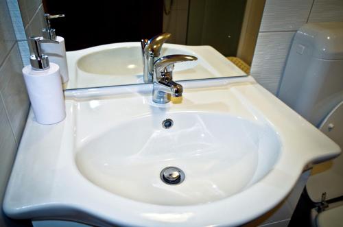 a white sink in a bathroom with a toilet at Garden House in Matulji