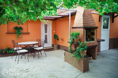 a patio with a table and chairs and a fireplace at Garden House in Matulji
