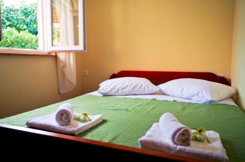 een slaapkamer met een bed met handdoeken en een raam bij Garden House in Matulji