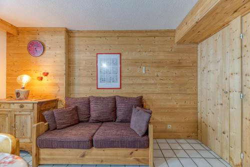 a couch in a room with wooden walls at Granges 32 - Beau Duplex Spacieux in Villard-Reculas
