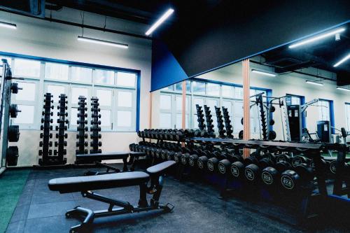 a gym with rows of dumbbells in a room at Habyt Kada at Maxwell in Singapore