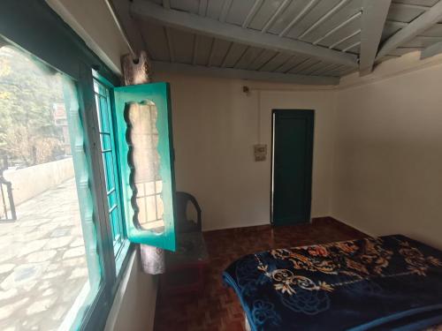 a room with a window and a bed in it at The Eleventh homestay in Kasol
