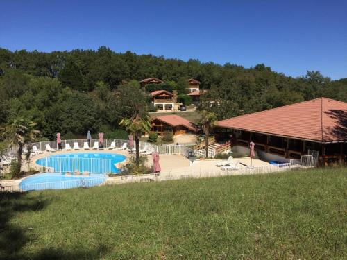 un complexe avec une piscine et un bâtiment dans l'établissement au CHAL'EVASION, à Mauroux