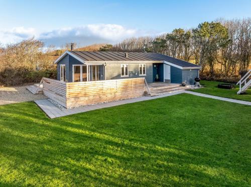 a small house with a large lawn in front of it at Beautiful Holiday Home With A Lovely View Of The Fjord And The Sea in Vestervig