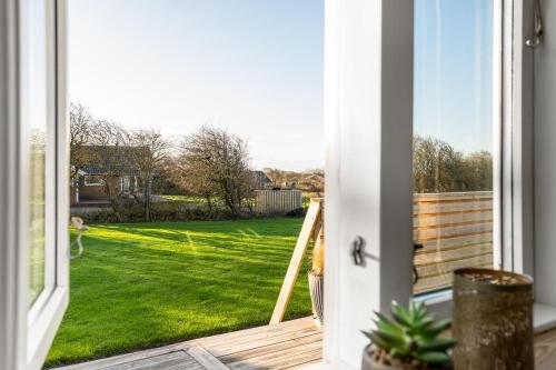 an open door with a view of a yard at Beautiful Holiday Home With A Lovely View Of The Fjord And The Sea in Vestervig