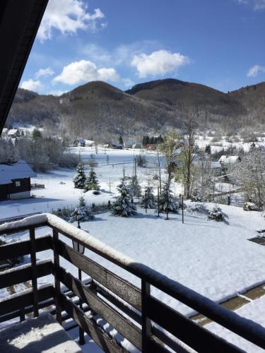 a view of a snow covered field from a balcony at CASA NATURA - charming chalet with hot tub in Tuk Vojni
