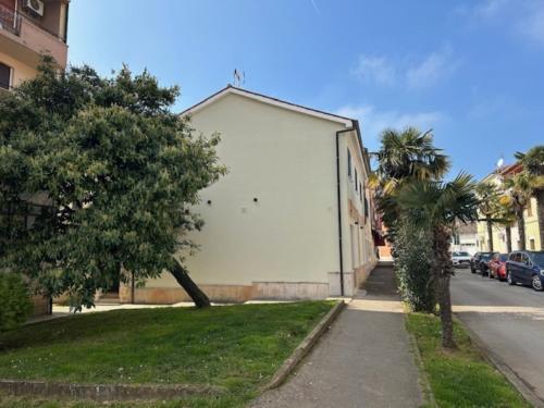 a white building on the side of a street at Apartments Urban in Poreč